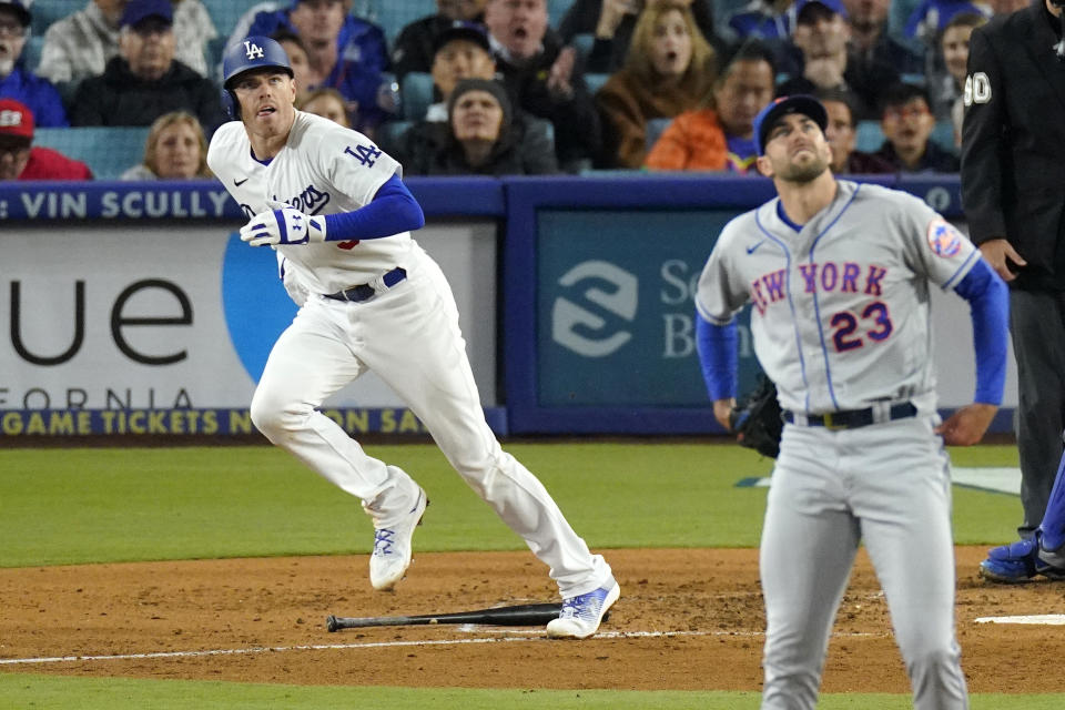 Los Angeles Dodgers' Freddie Freeman, left, heads to first after hitting a two-run home run as New York Mets starting pitcher David Peterson watches during the fifth inning of a baseball game Monday, April 17, 2023, in Los Angeles. (AP Photo/Mark J. Terrill)