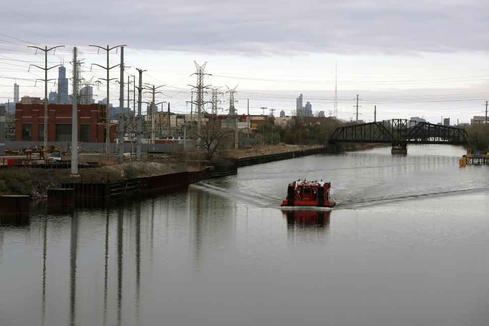 A towing vessel crosses Chicago River along the industrial section of the Little Village neighborhood on Sunday, April 11, 2021. President Joe Biden’s proposal to get rid of every lead water pipe in the country could have huge ramifications. That's especially true in communities where a large number of Black, Latino and low-income residents have been left effectively drinking from a lead straw. The problem persists decades after scientists established that lead consumption is unsafe at any level. Biden announced the pipe proposal as part of his $2.3 trillion infrastructure package. (AP Photo/Shafkat Anowar)