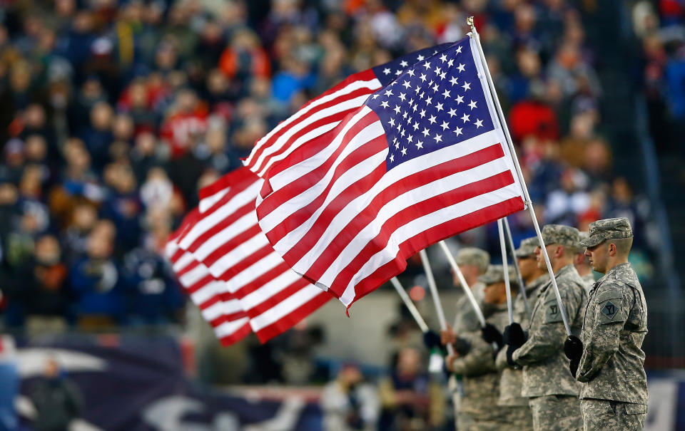 FOXBORO, MA - JANUARY 10: Military members hold flags before the 2014 AFC Divisional Playoffs game between the New England Patriots and the Baltimore Ravens at Gillette Stadium on January 10, 2015 in Foxboro, Massachusetts.  (Photo by Jared Wickerham/Getty Images)