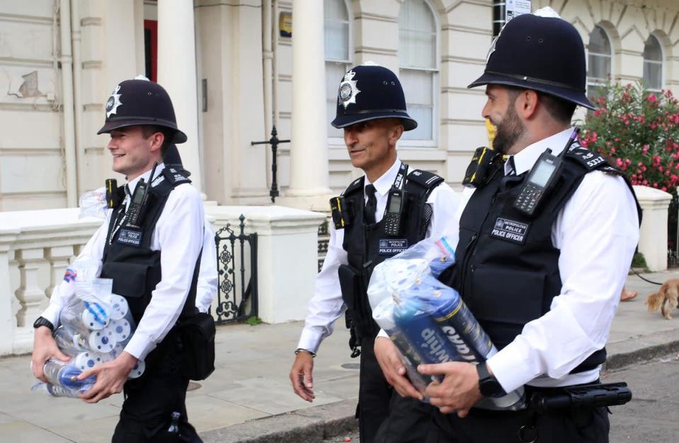 Police officers carry canisters of nitrous oxide, known as laughing gas (AFP via Getty Images)