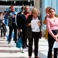 Bewerber stehen bei einer Jobmesse Schlange.