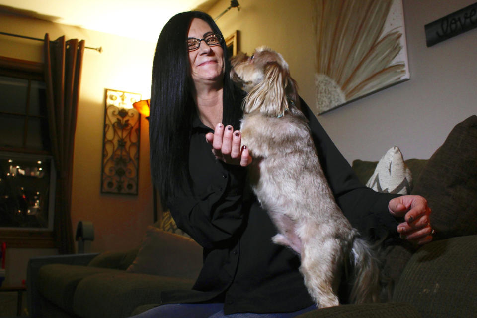 In this Nov. 5, 2019 photo, Amy Carter lets her dog Bentley lick her face at her home in St. Francis, Wis. Carter gives him CBD, which she says has reduced his epilepsy-related seizures. The federal government has yet to establish standards for CBD that will help pet owners know whether it works and how much to give. But the lack of regulation has not stopped some from buying it, fueling a $400 million CBD market for pets that grew more than tenfold since last year and is expected to reach $1.7 billion by 2023, according to the cannabis research firm Brightfield Group. (AP Photo/Carrie Antlfinger)