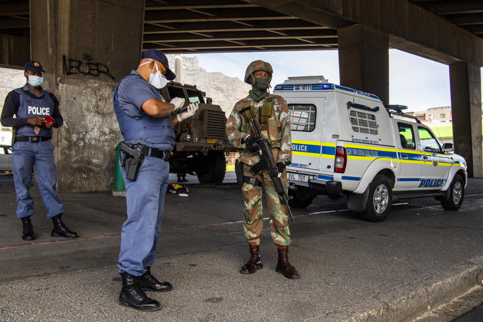 A policeman and soldier man a roadblock in Cape Town, South Africa, Friday, March 27, 2020, after South Africa went into a nationwide lockdown for 21 days in an effort to mitigate the spread to the coronavirus. The new coronavirus causes mild or moderate symptoms for most people, but for some, especially older adults and people with existing health problems, it can cause more severe illness or death(AP Photo)