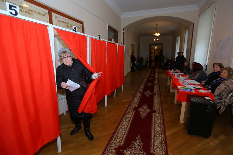 A woman attends voting at a polling station during a snap parliamentary election in Baku