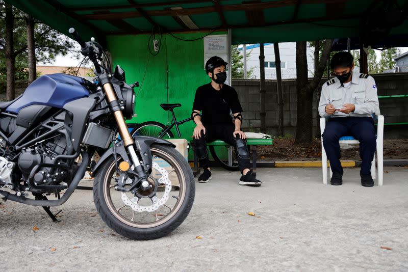 You Young-sik talks with a motorbike instructor during a training session amid the coronavirus disease (COVID-19) pandemic in Seoul