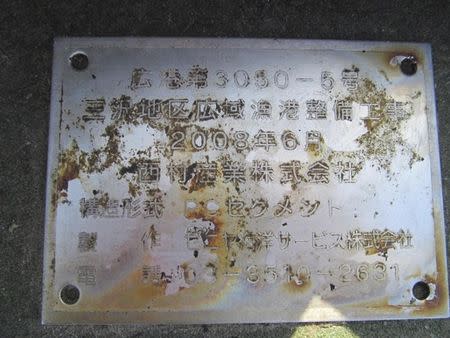 Oregon Parks and Recreation Department photograph shows a metal placard bearing Japanese writing that details manufacturer and fabrication date, among other information on a very large and heavy dock measuring 7' tall, 19' wide and 66' long that has washed ashore on Agate Beach one mile north of Newport, Oregon on June 6, 2012. The writing reads "Misawa region wide-area fishery harbor improvement work. June 2008, Nishimura Sangyo Co., Type of Structure: PC Segment, Constructor: Zeniya Kaiyo Service Co. REUTERS/Oregon Parks and Recreation Department/Handout