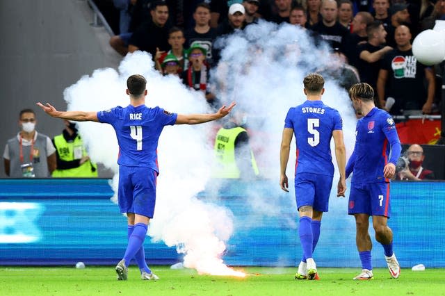 England’s Declan Rice gestures towards the fans as a flare is thrown onto the pitch in Budapest 