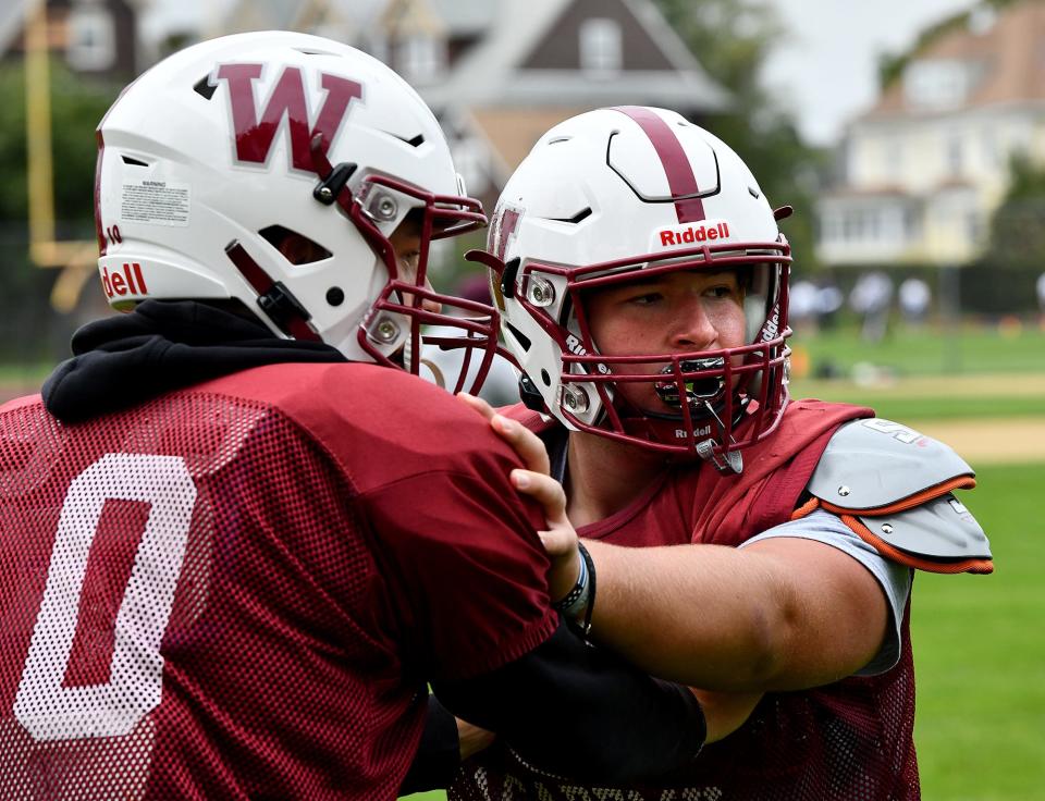 Worcester Academy's Paul Saucier, right, and JJ Stein of Webster go through blocking drills during football practice.
