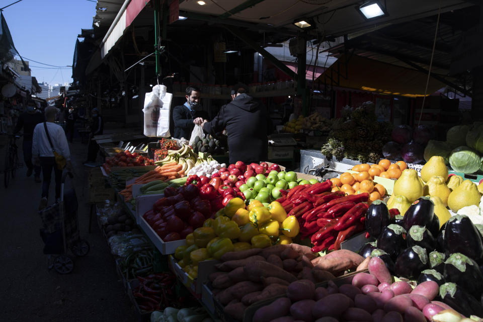 Israelis shop at a market in Tel Aviv, Israel, Sunday, Feb. 21, 2021. Israel lifted many of its coronavirus restrictions and started reopening its economy Sunday as the country's vaccination drive and third nationwide lockdown have started to bring down infections. (AP Photo/Sebastian Scheiner)