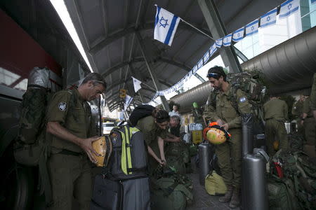 Israeli soldiers, members of an aid delegation, prepare their equipment as they wait for a flight to Nepal at Ben Gurion international airport near Tel Aviv, Israel April 26, 2015. Israel is sending to Nepal a multi-department medical facility consisting of medical staff, members of the IDF National Search and Rescue Unit and approximately 95 tons of humanitarian and medical supplies. An 7.9 magnitude earthquake struck the densely populated Kathmandu Valley on Saturday noon local time, killing more than 2,400 people and leaving tens of thousands without food, water or shelter. REUTERS/Baz Ratner