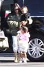 <p>Kim wears an oversized camo bomber, white sweatpants, beige yeezy lace-up boots, and oversized sunnies while traveling to a family vacation at a Van Nuys Airport in LA. </p><p>Her daughter North wears a baby pink "West" hoodie, white cut-off shorts, and black hi-top Converse Sneakers while Saint is dressed in a black hoodie, black and red Adidas trackpants, and itty bitty sneakers. </p>