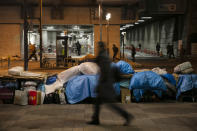 In this Tuesday, Jan. 21, 2020, photo, homeless people's belongings are piled up on a sidewalk, in the Shinjuku district of Tokyo. Like the U.S., Japan has a relatively high poverty rate for a wealthy nation. It also is less generous with social welfare than countries in Europe, and lacks the sorts of private charities prevalent in the U.S. (AP Photo/Jae C. Hong)