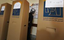 <p>An Iraqi Kurdish man dressed in traditional costume looks at the names on the electoral lists hung behind him before ticking his ballot behind a voting booth at a polling station in Arbil, the capital of the Kurdish autonomous region in northern Iraq, on May 12, 2018 as the country votes in the first parliamentary election since declaring victory over the Islamic State (IS) group. (Photo: Safin Hamed/AFP/Getty Images) </p>