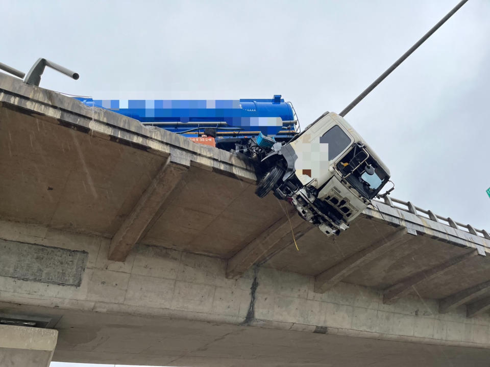 台61線快速道路南下47公里高架橋新屋永安段，5日早上一輛聯結車疑似車速過快衝撞高架橋護欄，車頭懸空卡在橋上，駕駛則墜落在平面道路無呼吸心跳，緊急送醫急救仍宣告不治。（翻攝照片）