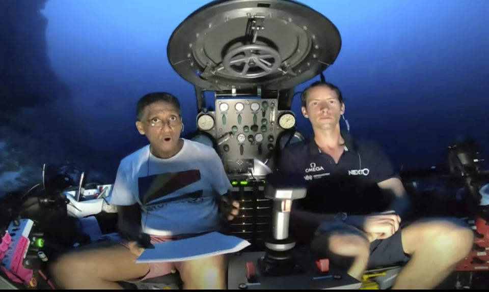 An image taken from video issued by Nekton shows Seychelles President Danny Faure, left, speaking from inside a submersible from the vessel Ocean Zephyr, under the water off the coast of Desroches, in the outer islands of Seychelles Sunday April 14, 2019. Faure toured the vessel and was presented with some of the findings and observations made by a British-led science expedition documenting changes taking place beneath the waves that could affect billions of people in the surrounding region over the coming decades (Nekton via AP)