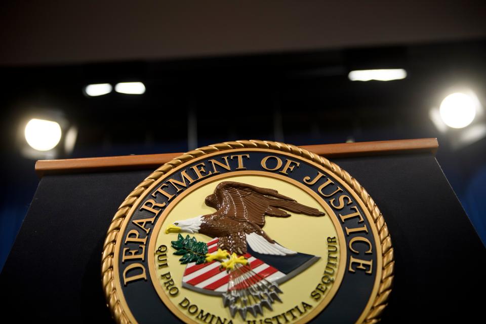 An empty podium emblazoned with seal that reads: Department of Justice.