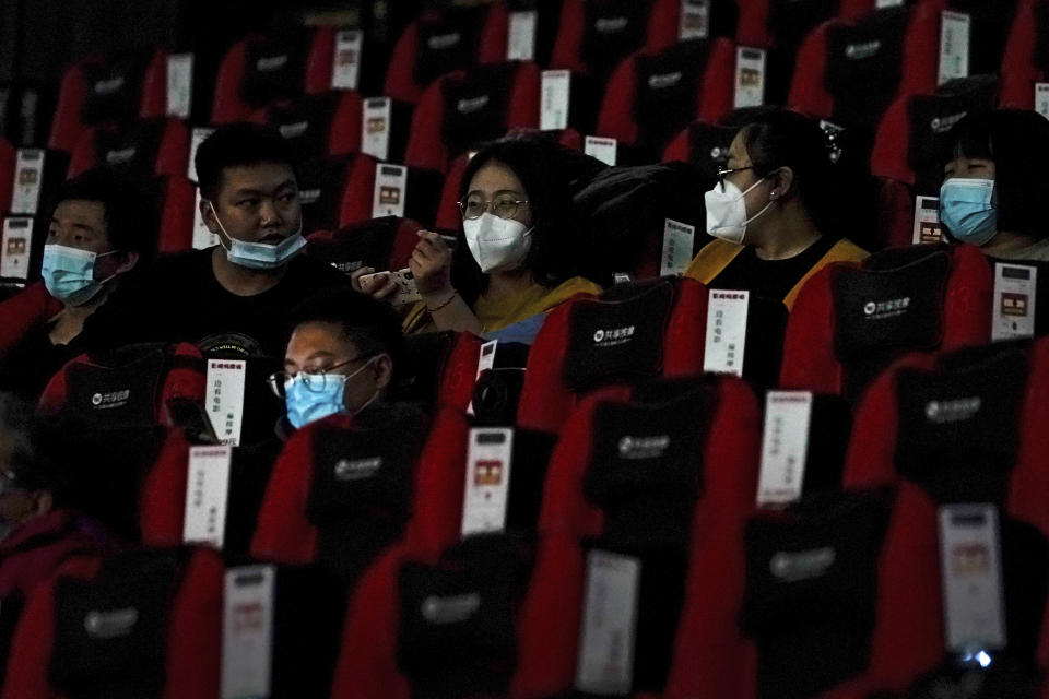 People wearing face masks to help curb the spread of the coronavirus chat each other as the watch a film at Poly Cinema in Beijing on Thursday, Feb. 25, 2021. With coronavirus well under control in China and cinemas running at half capacity, moviegoers are smashing China's box office records, setting a new high mark for ticket sales in February, with domestic productions far outpacing their Hollywood competitors. (AP Photo/Andy Wong)