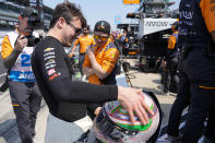 Pato O'Ward, of Mexico, shows the paint job on his helmet to a member of his crew during practice for the Indianapolis 500 auto race at Indianapolis Motor Speedway in Indianapolis, Friday, May 19, 2023. (AP Photo/Michael Conroy)