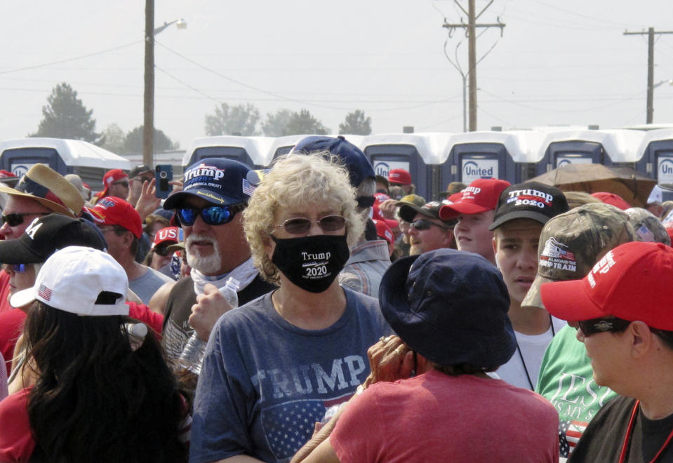 People line up outside the gates three hours before President Donald Trump is scheduled to speak Saturday night at a campaign rally at Minden-Tahoe Airport under smoky skies from California wildfires along the Sierra Nevada's eastern front in Minden, Nev., Saturday, Sept. 12, 2020 (AP Photo/Scott Sonner)