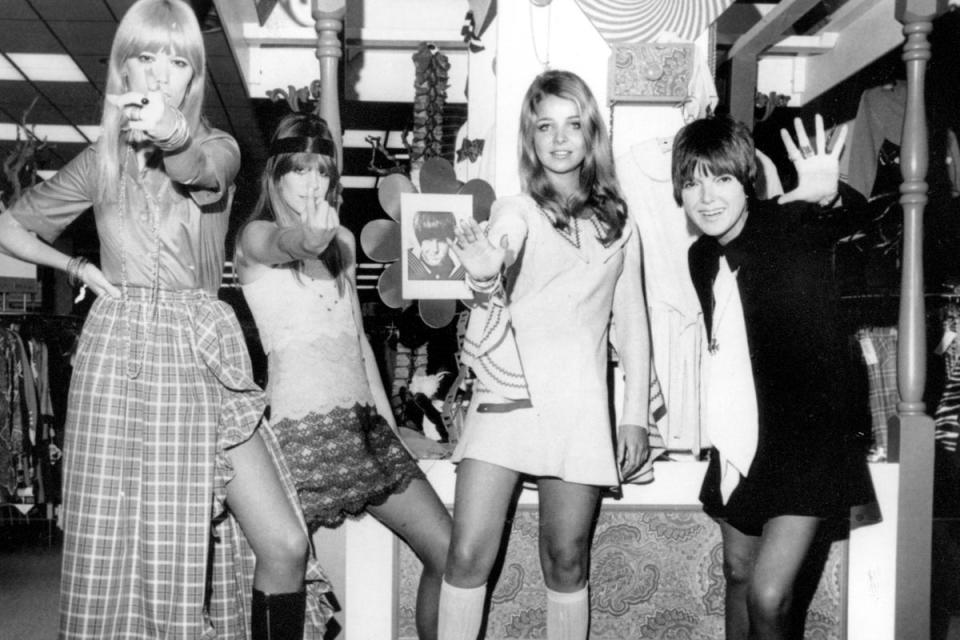 Mary Quant, right, waves as she poses with models, from left Amanda Tear, Rory Davis and Penny Yates, wearing her Mod creations in Little Rock, Arkansas, in 1968 (AP)