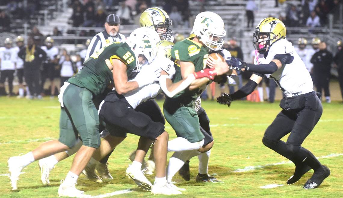 Pioneer High School defenders work to bring down Hilmar senior running back Logan Cardoso during the Yellowjackets’ 41-32 playoff win on Thursday, Nov. 9, 2023. Shawn Jansen/Sjansen@mercedsun-star.com