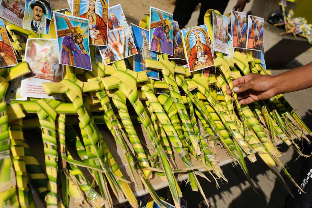 A man chooses a palm cross to buy on Palm Sunday near a church in Caracas, Venezuela, in 2022. <a href="https://www.gettyimages.com/detail/news-photo/man-chooses-a-palm-cross-to-buy-during-palm-sunday-near-a-news-photo/1239899434?adppopup=true" rel="nofollow noopener" target="_blank" data-ylk="slk:Javier Campos/NurPhoto via Getty Images;elm:context_link;itc:0;sec:content-canvas" class="link ">Javier Campos/NurPhoto via Getty Images</a>