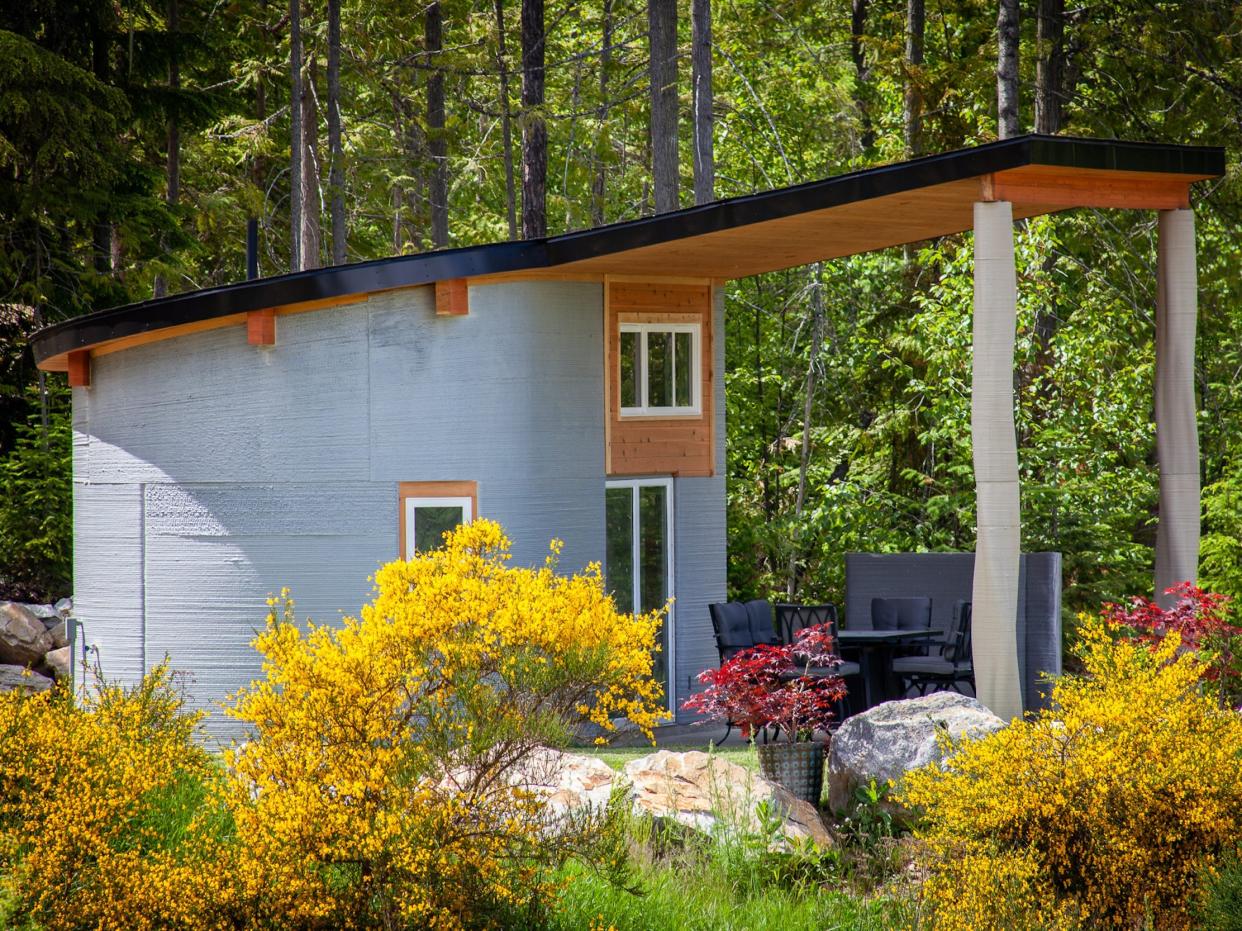 the exterior of the Fibonacci House among trees and grass