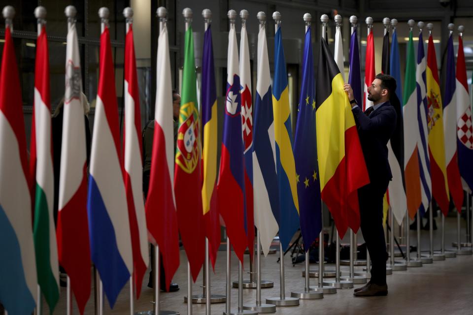 A worker puts the final touches on a display of flags of EU member states ahead of a European Council in Brussels (EPA)