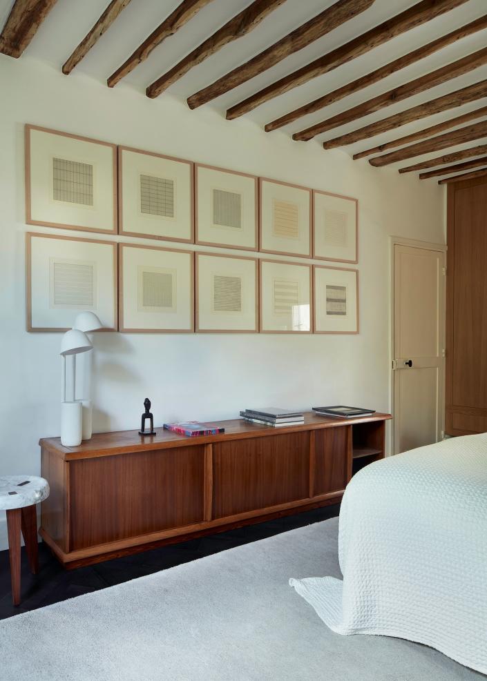 In the master bedroom, a wall of Agnes Martin drawings, a Charlotte Perriand sideboard circa 1947, and a lamp by the Bouroullec brothers.