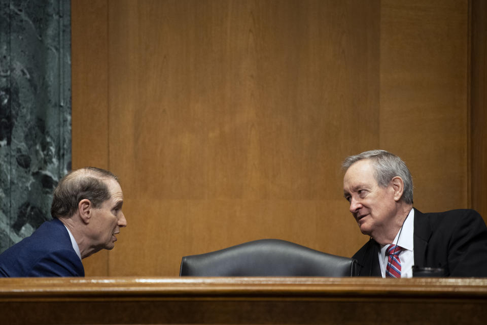 UNITED STATES - April 15: Chairman Ron Wyden, D-Ore., left, talks with ranking member Mike Crapo, R-Idao, before the start of the Senate Finance Committee nomination hearings for Andrea Palm to be deputy HHS secretary and Chiquita Brooks-LaSure to be administrator of the Centers for Medicare & Medicaid Services in Washington on Thursday, April 15, 2021. (Photo by Caroline Brehman/CQ-Roll Call, Inc via Getty Images)