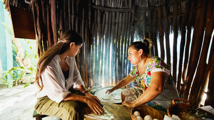 Woman tourist taking a cooking lesson from a local home cook in Mexico