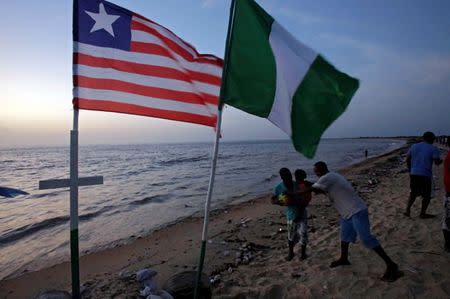 Pepole play near flags on the beach in the township of West Point, in Monrovia, Liberia, October 18, 2017. REUTERS/Thierry Gouegnon