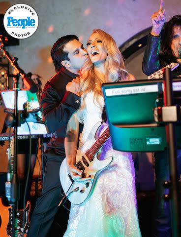 <p>DeAngelo Castro for SYMBOLL</p> Nita Strauss performs with Alice Cooper (far right) at her wedding