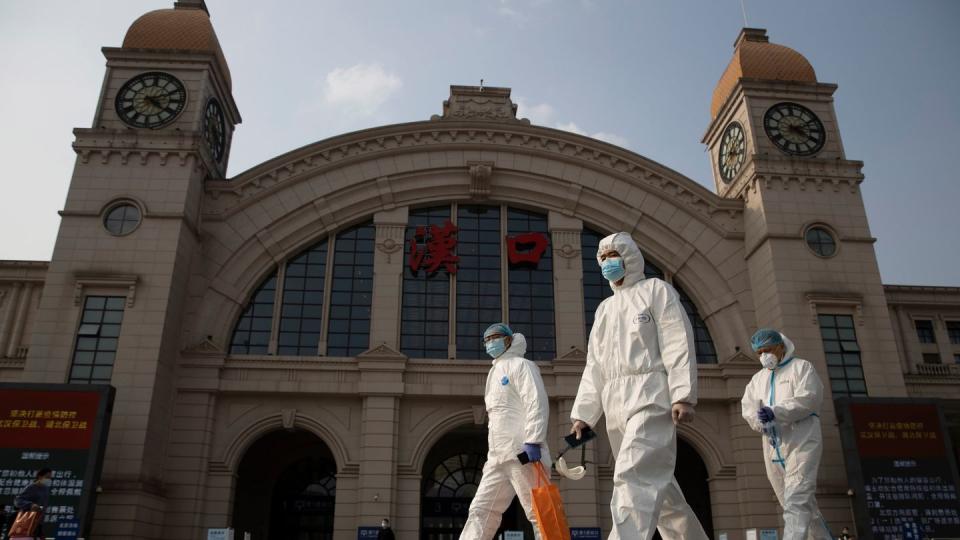 Arbeiter in Schutzanzügen am Bahnhof Hankou.