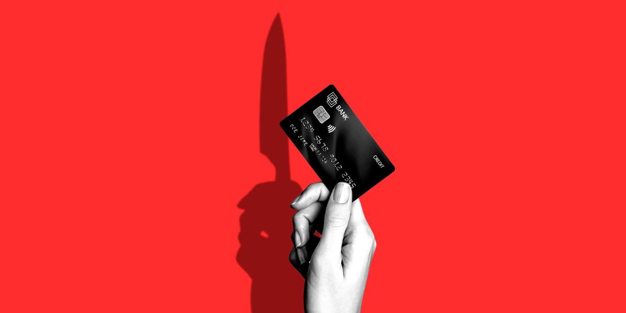 A hand holding a credit card with a knife as its shadow