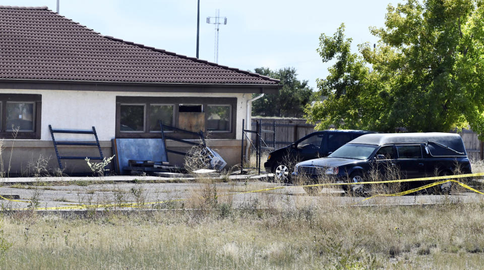 FILE - A hearse and debris can be seen at the rear of the Return to Nature Funeral Home, Oct. 5, 2023, in Penrose, Colo. Jon and Carie Hallford, the owners of the Colorado funeral home where 190 decaying bodies were found, are set to appear in court Tuesday, Dec. 5, facing allegations that they abused corpses, stole, money laundered and forged documents. (Jerilee Bennett/The Gazette via AP, File)