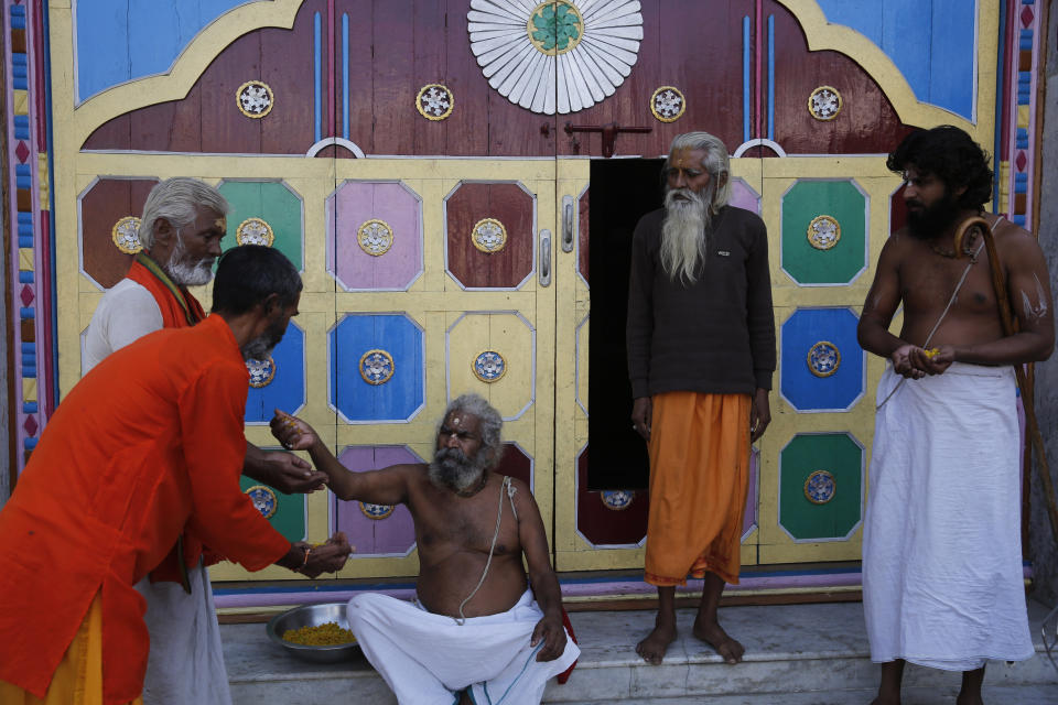 Hindu holy men celebrate the verdict in a decades-old land title dispute between Muslims and Hindus, in Ayodhya, India , Saturday, Nov. 9, 2019. India's Supreme Court on Saturday ruled in favor of a Hindu temple on a disputed religious ground and ordered that alternative land be given to Muslims to build a mosque. The dispute over land ownership has been one of the country's most contentious issues. (AP Photo/Rajesh Kumar Singh)