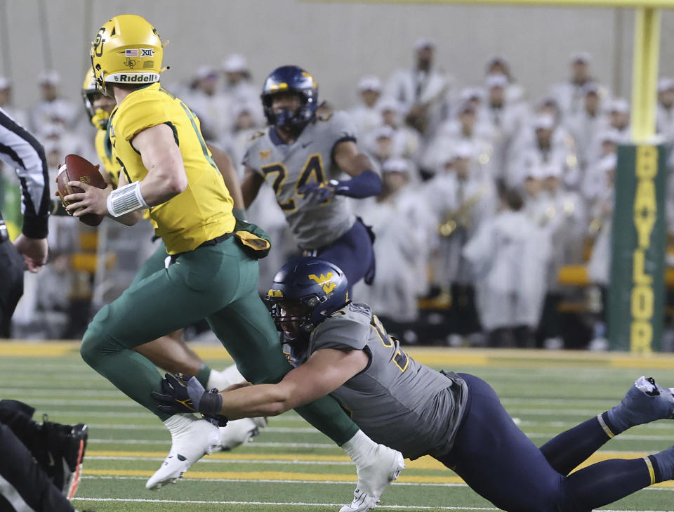 West Virginia defensive lineman Edward Vesterinen, right, sacks Baylor quarterback Sawyer Robertson, left, in the second half of an NCAA college football game, Saturday, Nov. 25, 2023, in Waco, Texas. (Jerry Larson/Waco Tribune-Herald, via AP)