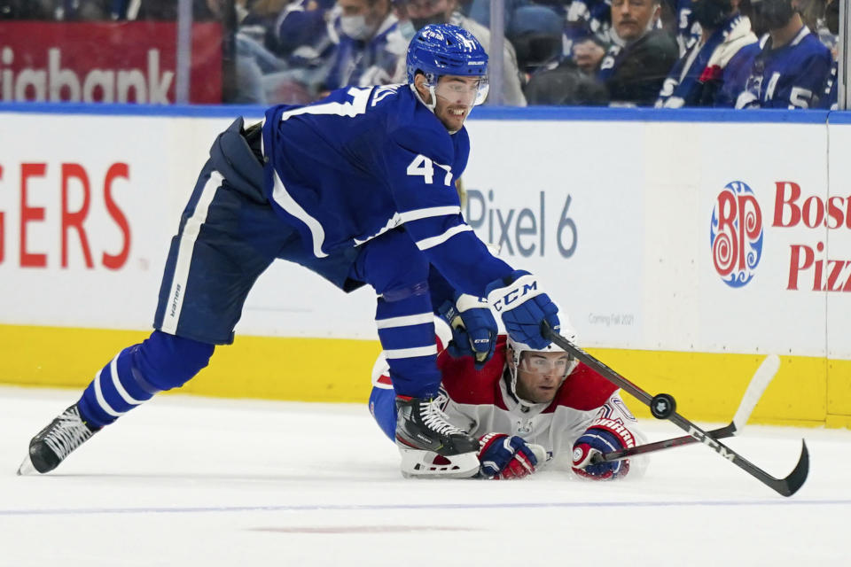 Toronto Maple Leafs forward Pierre Engvall (47) steals the puck from a fallen Montreal Canadiens defenseman Chris Wideman (20) during the second period of an NHL hockey game Wednesday, Oct. 13, 2021, in Toronto. (Evan Buhler/The Canadian Press via AP)