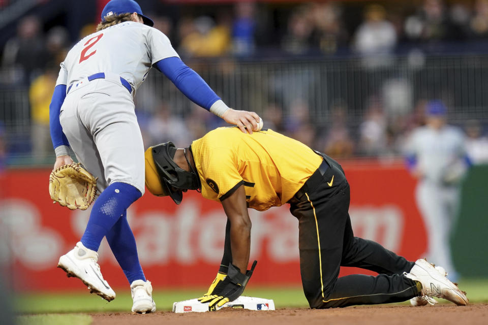 Pittsburgh Pirates' Michael A. Taylor, right, gets safely to second base with a steal against Chicago Cubs shortstop Nico Hoerner, left, during the second inning of a baseball game Friday, May 10, 2024, in Pittsburgh. (AP Photo/Matt Freed)