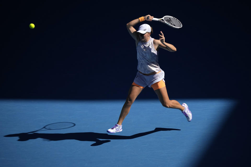 Iga Swiatek of Poland plays a forehand return to Cristina Bucsa of Spain during their third round match at the Australian Open tennis championship in Melbourne, Australia, Friday, Jan. 20, 2023. (AP Photo/Dita Alangkara)