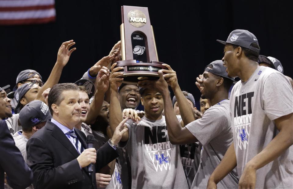 Kentucky's Aaron Harrison and his teammates hold up their trophy after an NCAA Midwest Regional final college basketball tournament game against Michigan Sunday, March 30, 2014, in Indianapolis. Kentucky won 75-72 to advance to the Final Four. (AP Photo/David J. Phillip)