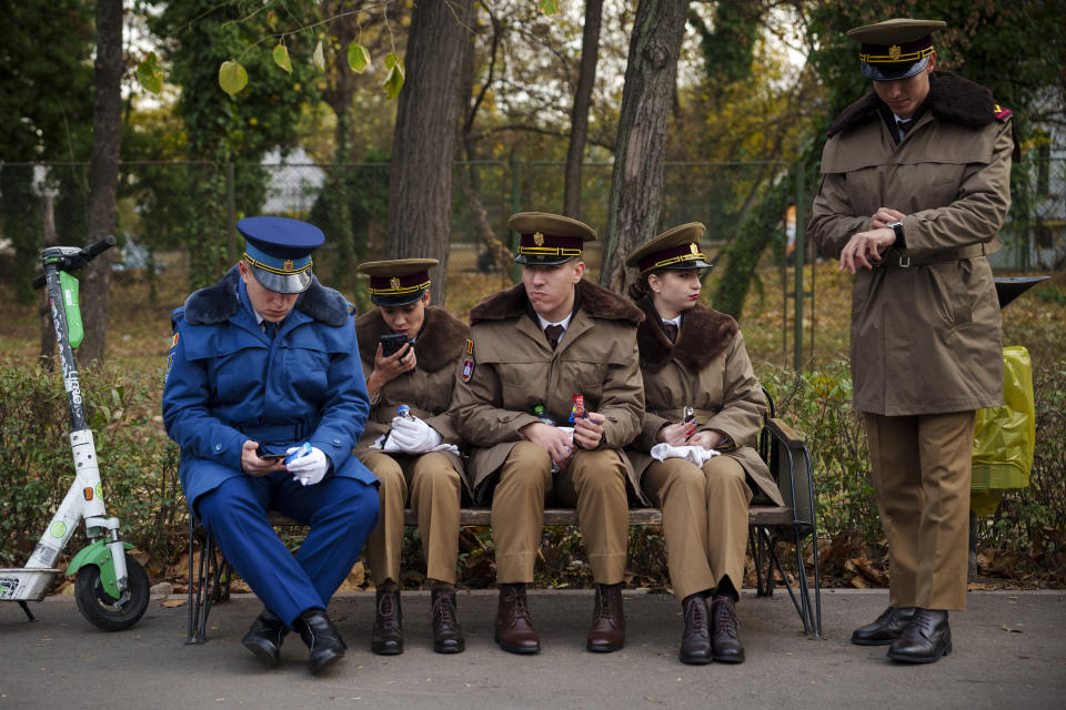 Military cadets sit on a bench before taking part in the National Day parade in Bucharest, Romania, Friday, Dec. 1, 2023. Tens of thousands of people turned out in Romania's capital on Friday to watch a military parade that included troops from NATO allies to mark the country's National Day. (AP Photo/Vadim Ghirda)