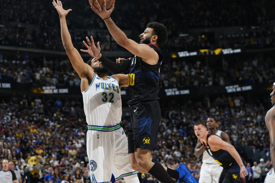 Denver Nuggets guard Jamal Murray, right, drives to the basket as Minnesota Timberwolves center Karl-Anthony Towns defends in the first half of Game 7 of an NBA second-round playoff series, Sunday, May 19, 2024, in Denver. (AP Photo/David Zalubowski)