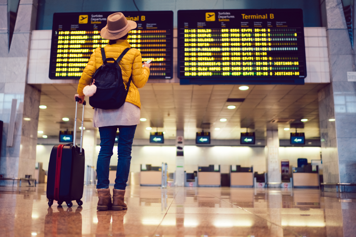 Woman in an airport looking at the flight schedule