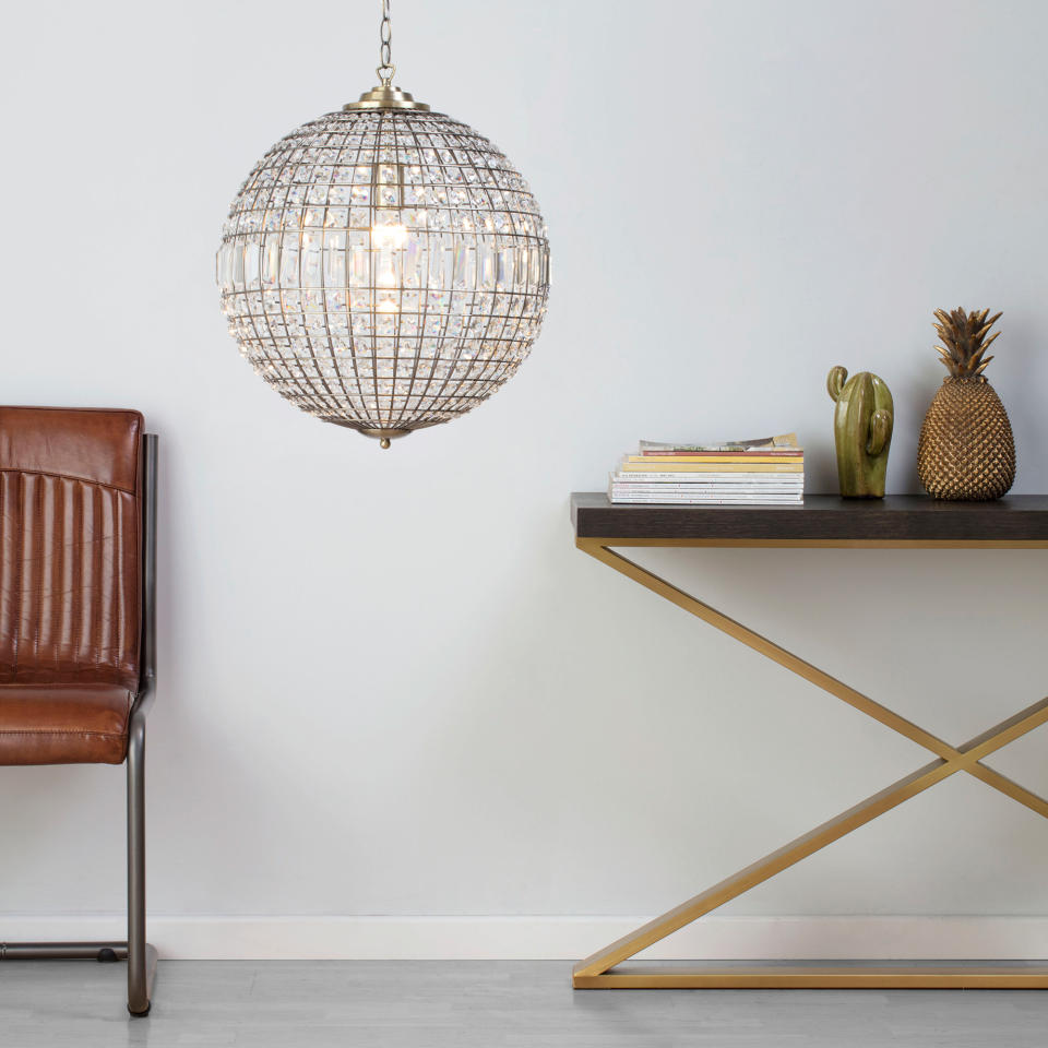 Crystal ball pendant light above a console table