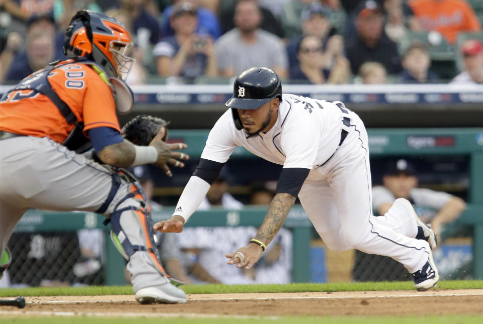 Detroit Tigers' Harold Castro dives into home plate to score against Houston Astros' Martin Maldonado on a single by Jonathan Schoop during the fifth inning of the second baseball game of a doubleheader Saturday, June 26, 2021, in Detroit. (AP Photo/Duane Burleson)