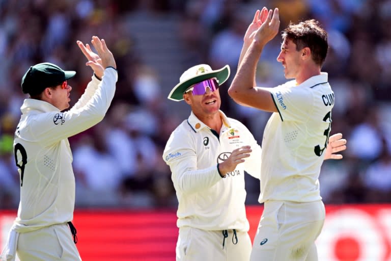 Australia's Pat Cummins (R) celebrates with teammates Steve Smith (L) and David Warner (C) after dismissing Pakistan's batsman Barbar Azam (William WEST)