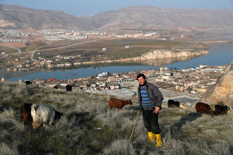 Shepherd Yasar Agilday is seen as he herds graze on top of a cliff above Hasankeyf