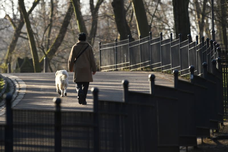 A woman walks with her dog at the Volkspark Friedrichshain in Berlin